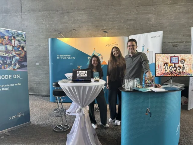 Drei Personen vor Messestand