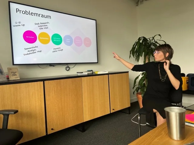 Person präsentiert Grafik an Fernseher