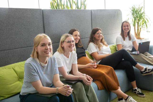 Fünf junge Frauen sitzen auf einem Sofa im Xenium-Büro