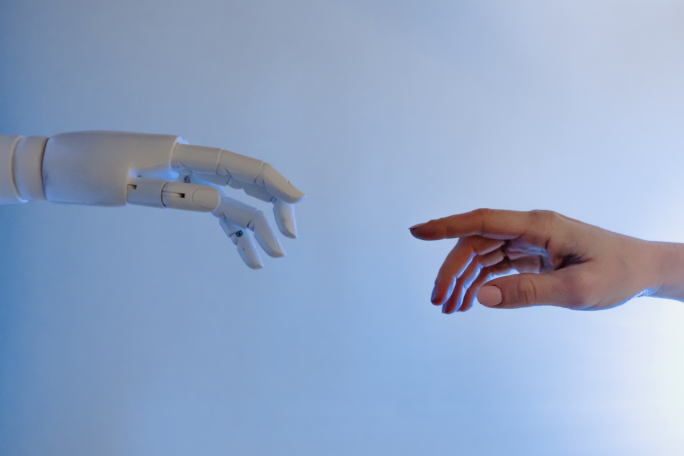 Eine Roboterhand und eine Menschenhand, die sich fast berühren