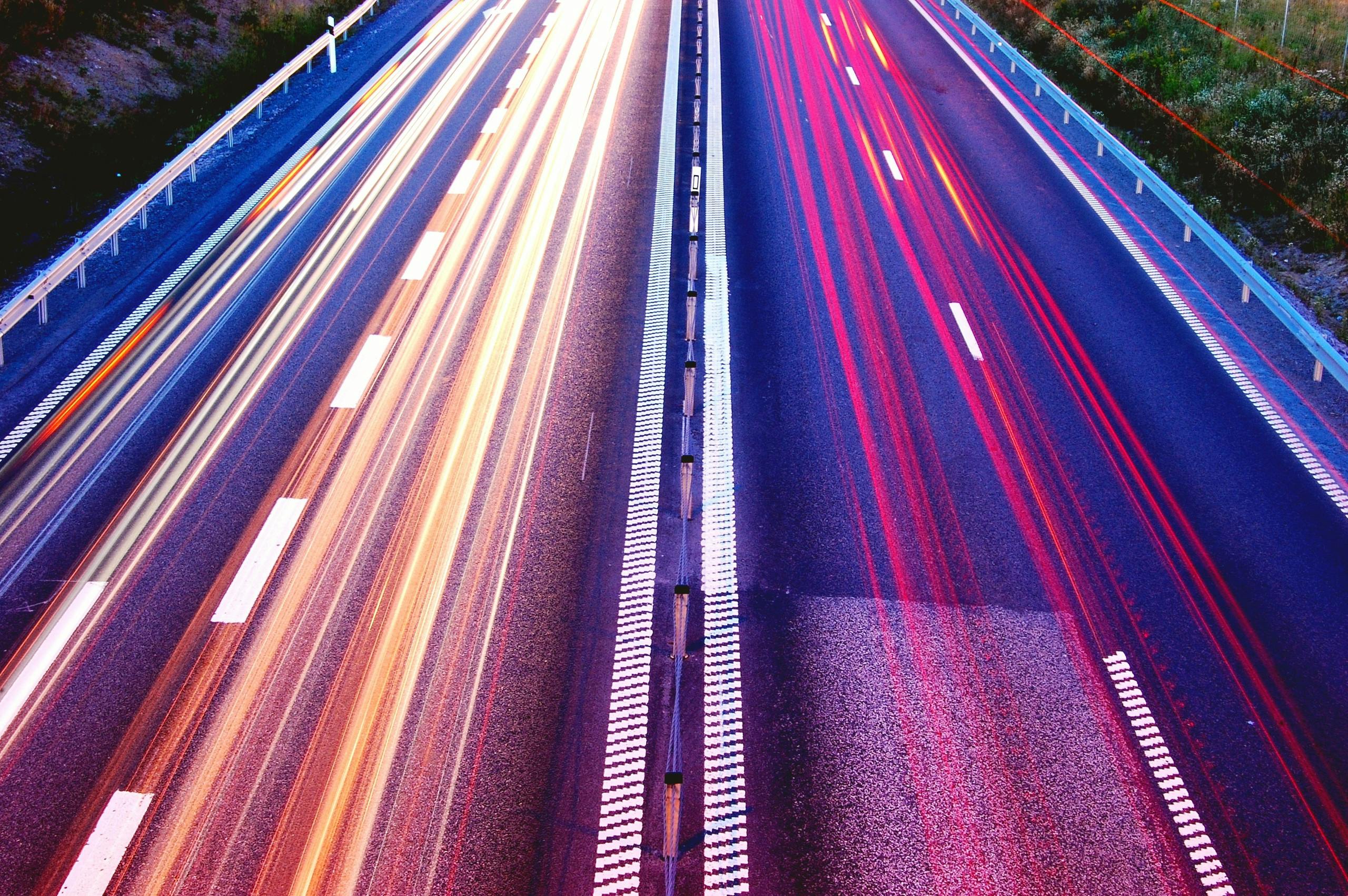 Autobahn mit Lichtern vorbeifahrender Autos